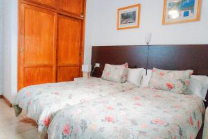 a bedroom with a large bed with a wooden headboard at Casa Lago Azul 49 in Los Cancajos