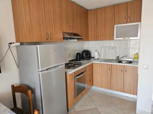 a kitchen with wooden cabinets and a refrigerator at Apartment Ivan in Tribunj