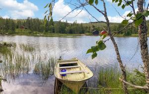 ein Holzboot am Ufer eines Sees in der Unterkunft Awesome Home In Namsskogan in Namsskogan