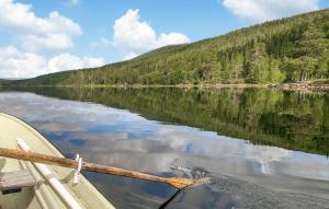 ein Boot auf einem See mit Spiegelung im Wasser in der Unterkunft Awesome Home In Namsskogan in Namsskogan