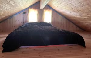 ein Bett in einem Holzzimmer mit zwei Fenstern in der Unterkunft Awesome Home In Namsskogan in Namsskogan