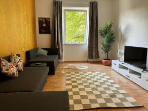 a living room with a couch and a tv at Casa Grande in Duisburg