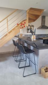 a kitchen with a counter and chairs in a room at Gîte Angers proche in Briollay