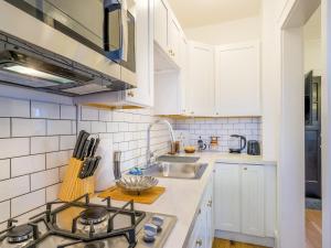 a kitchen with white cabinets and a sink at Highfall Hideaway Your Cozy Escapewi-fitvpets in Rochester