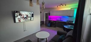 Una sala de estar con un sofá y un televisor en una pared. en ASP D5 - VIVO Mall, en Floreşti