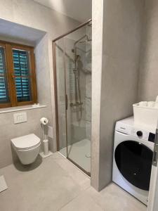 a bathroom with a shower and a toilet and a washing machine at Old town Pjaca Makarska in Makarska +3 photos
