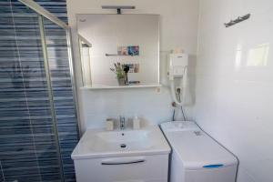 Un baño blanco con lavabo y ducha. en Apartmani Babić, en Sevid 36 fotos más