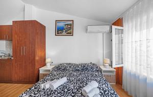 a bedroom with a bed and cabinets and a window at Stunning Apartment In Vodice in Vodice +11 photos