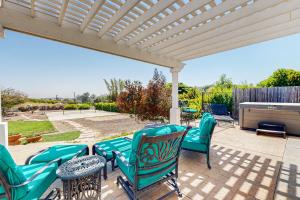 a patio with chairs and tables and a pergola at Tierra De La Maracuyá in Fallbrook