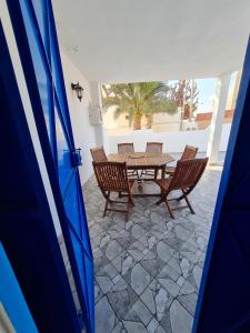 a patio with a table and chairs on a stone floor at Maison d'été hessi Jerbi ras marmour in Zarzis