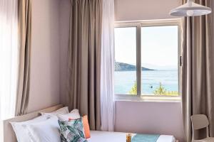 a bedroom with a window with a view of the ocean at Himara City 24 - Central & Beach Access in Himare +11 photos