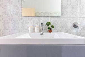 a white sink in a bathroom with potted plants at Himara City 24 - Central & Beach Access in Himare
