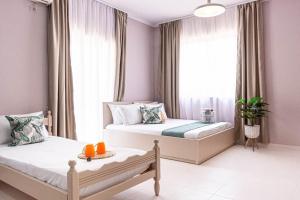 a bedroom with two beds and a window at Himara City 24 - Central & Beach Access in Himare