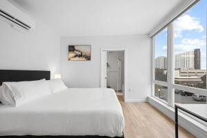a bedroom with a white bed and a large window at Comfy 1bd1ba Riverside Apt W Queenbdlaundrytv in Spokane