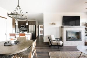 a living room with a table and a fireplace at New Luxe Condo - Hot Tub - Minutes to WP! - Fraser in Fraser