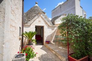 a house with a courtyard with plants and flowers at Trullimania in Alberobello