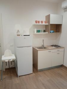 a small kitchen with a refrigerator and a sink at Mediterranea casa vacanza in Capaci