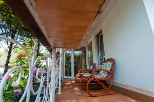 a porch with rocking chairs and flowers at Zacisze Zygmuntowo in Zygmuntowo