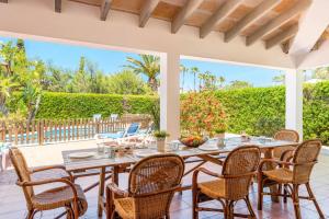 a dining room with a table and chairs on a patio at Villa Angel by Villa Plus in Son Xoriguer