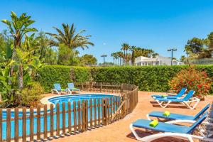 a swimming pool with lounge chairs and a fence at Villa Angel by Villa Plus in Son Xoriguer