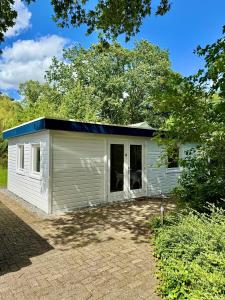 a small white shed with a blue roof at B&B Eekhoornpad in Tilburg