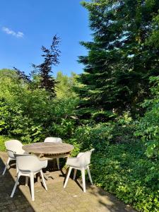 a table and chairs and a table and trees at B&B Eekhoornpad in Tilburg +26 photos