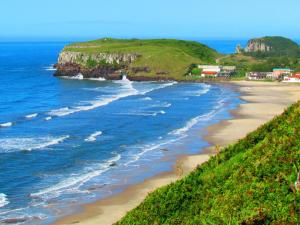 a view of a beach next to the ocean at Fique a poucos passos do Centro e da Praia - Jô in Torres