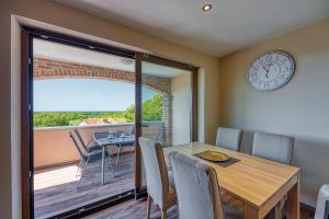 a dining room with a table and a clock on the wall at Apartment M- Panoramic View in Mugeba