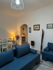 a living room with a blue couch and a dining room at Marielen House in Kampos Paros