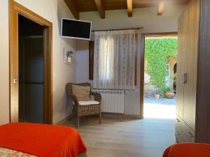 a bedroom with a bed and a chair and a sliding glass door at Casa Rural Santa Mariña in Portomarin