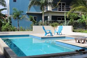 two blue chairs sitting next to a swimming pool at Azulita Resort in Willemstad