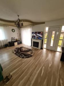 ein Wohnzimmer mit einem großen Raum mit einem großen Holzboden in der Unterkunft Casa din povesti in Crasna din Vale