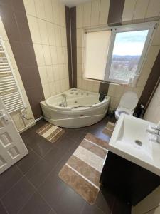 ein Badezimmer mit Badewanne und Waschbecken in der Unterkunft Casa din povesti in Crasna din Vale