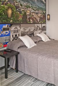 a bedroom with a large bed with a picture on the wall at JC Rooms Santo Domingo in Madrid