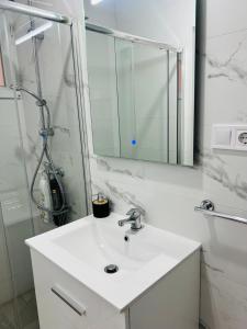 a white bathroom with a sink and a mirror at Apartamento céntrico Vinaros 1A in Vinarós