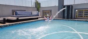 a swimming pool with a fountain in the middle at Adelina Hotel in Beestekraal