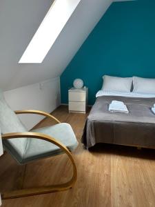 a bedroom with a bed and a blue wall at ZAMKOWE TARASY Apartamenty Old Town by stayly in Szczecin