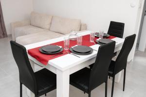 a white table with black chairs and a white couch at Silver Moon Residence 3 in Arad