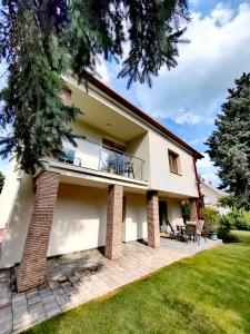 a house with a balcony and a patio at City Vendégház Balatonfüred in Balatonfüred +39 photos