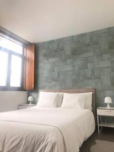 een slaapkamer met een groot bed en een stenen muur bij Coral Beach House in Viana do Castelo