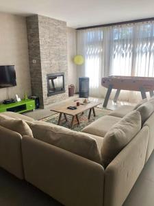 een woonkamer met een bank en een tafel bij Coral Beach House in Viana do Castelo