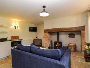 a living room with a couch and a fireplace at Kings Cottage - North in Broad Chalke +21 photos