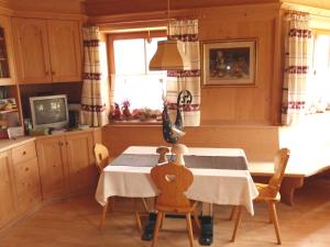 a kitchen with a table and chairs and a tv at Brunnerhof in Feldthurns