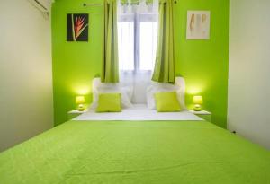 a green bedroom with a large bed with green walls at Maison charmante à Le Moule avec piscine partagée in Le Moule