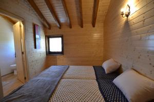 1 dormitorio con 1 cama en una habitación de madera en Branda da Aveleira, en Branda da Aveleira