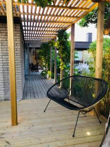 a bench sitting under a pergola on a patio at Villa i lugnt område nära hav in Ystad