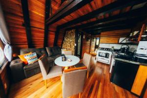 una sala de estar con un sofá y una mesa en Sítio Mar de Nuvens Chalés Morro da Igreja, Urubici, SC., en Urubici