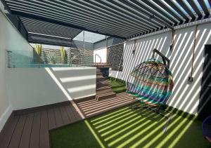 a patio with a swing on a deck at Cadillac Hotel Boutique in Mexico City