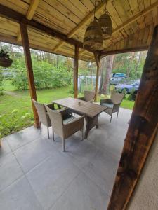 a wooden table and chairs on a patio at Zakątek nad Świdrem in Otwock