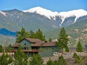 una casa verde con montagne innevate sullo sfondo di Air Conditioned Private Guest Suite a Roosville